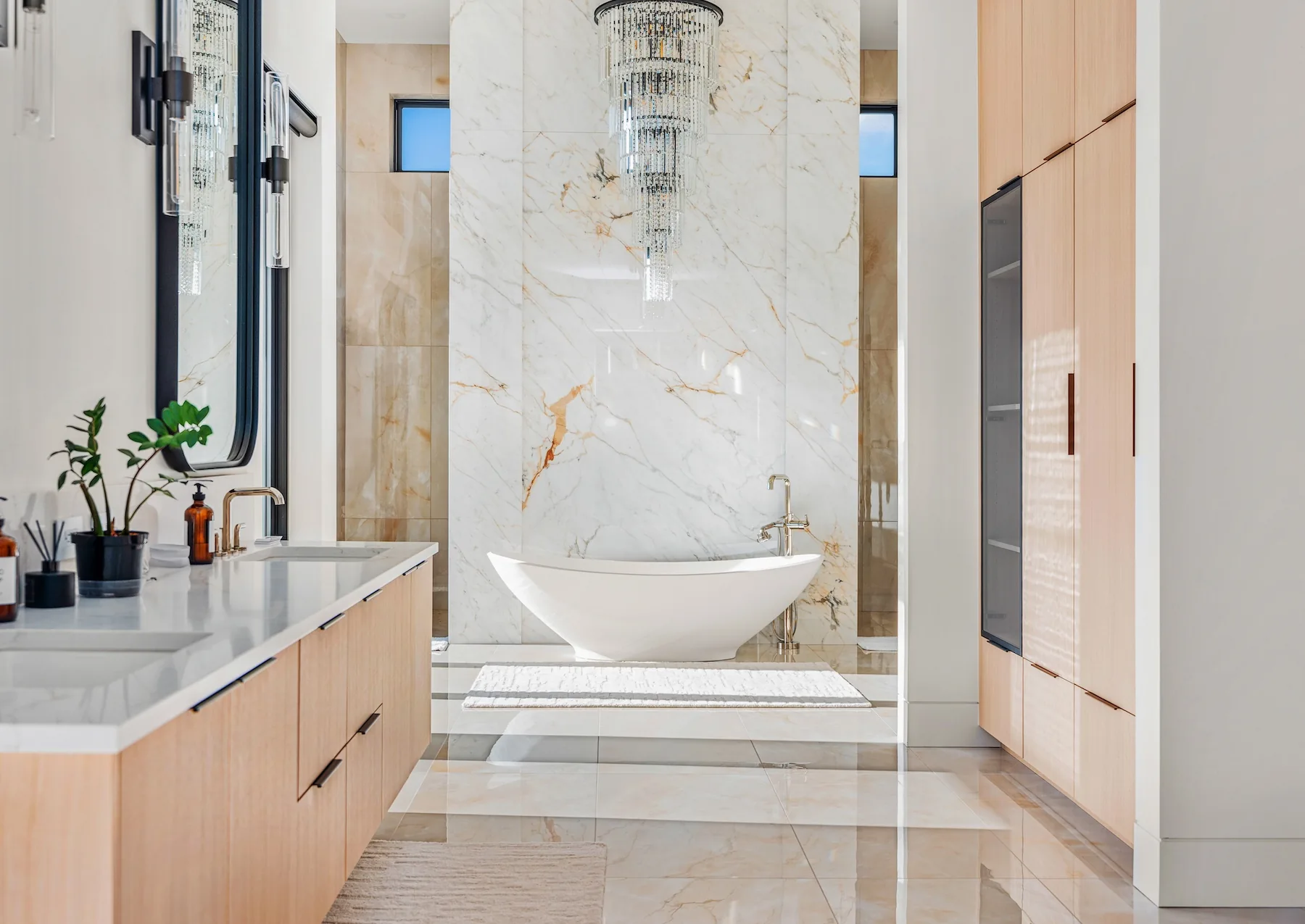 Free standing tub under large chandelier